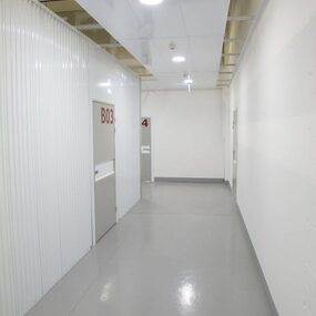 Heller Flur in einem Selfstorage-Lager mit weißen Türen und modernen Beleuchtungselementen.